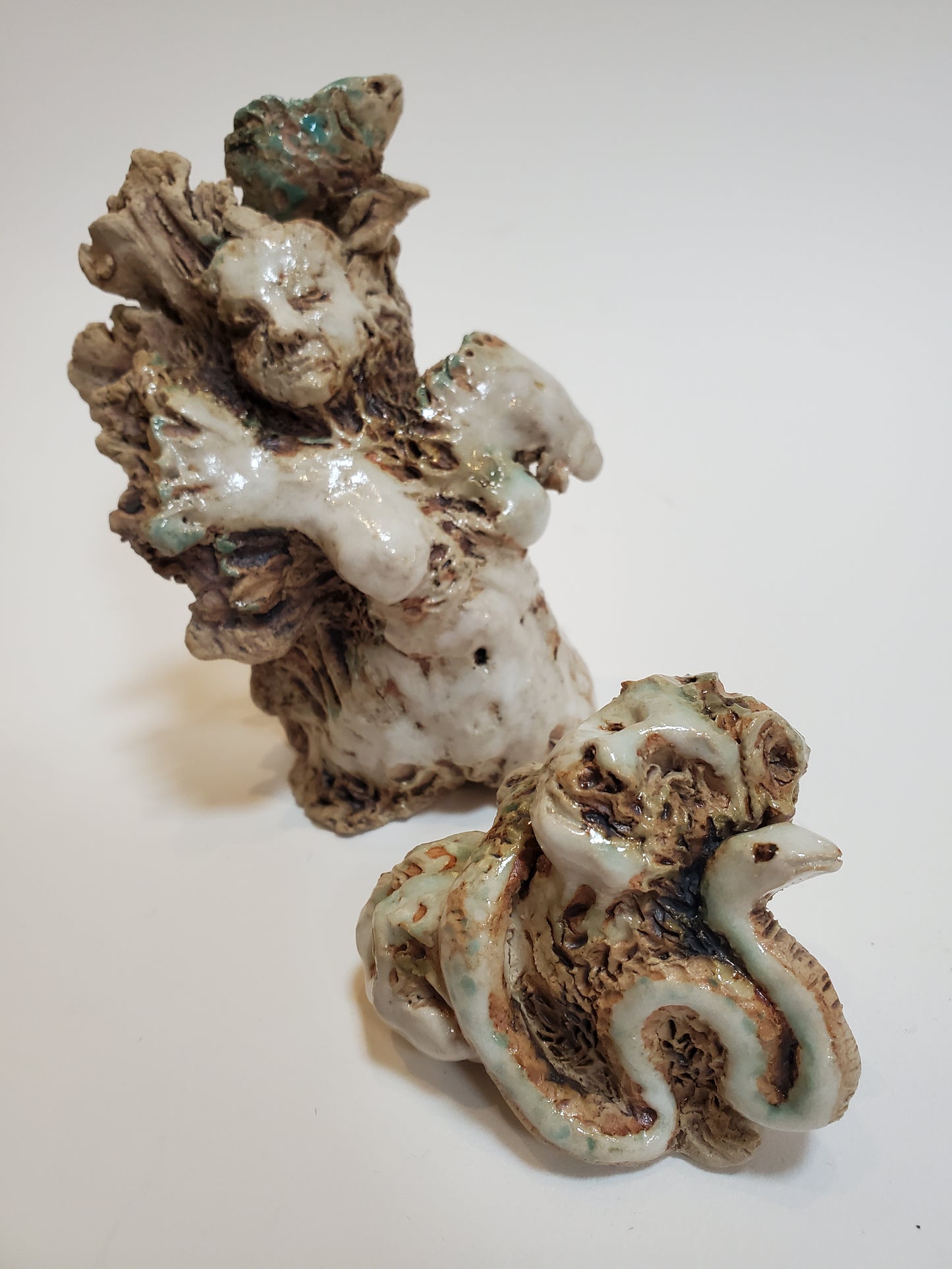 Set of 2 miniature ceramic sculptures, female figure with fish and shadow, figure with double-headed snake
